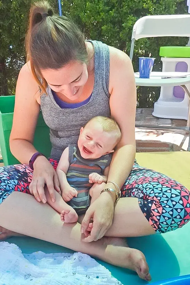 A caregiver laughing with a baby in her lap