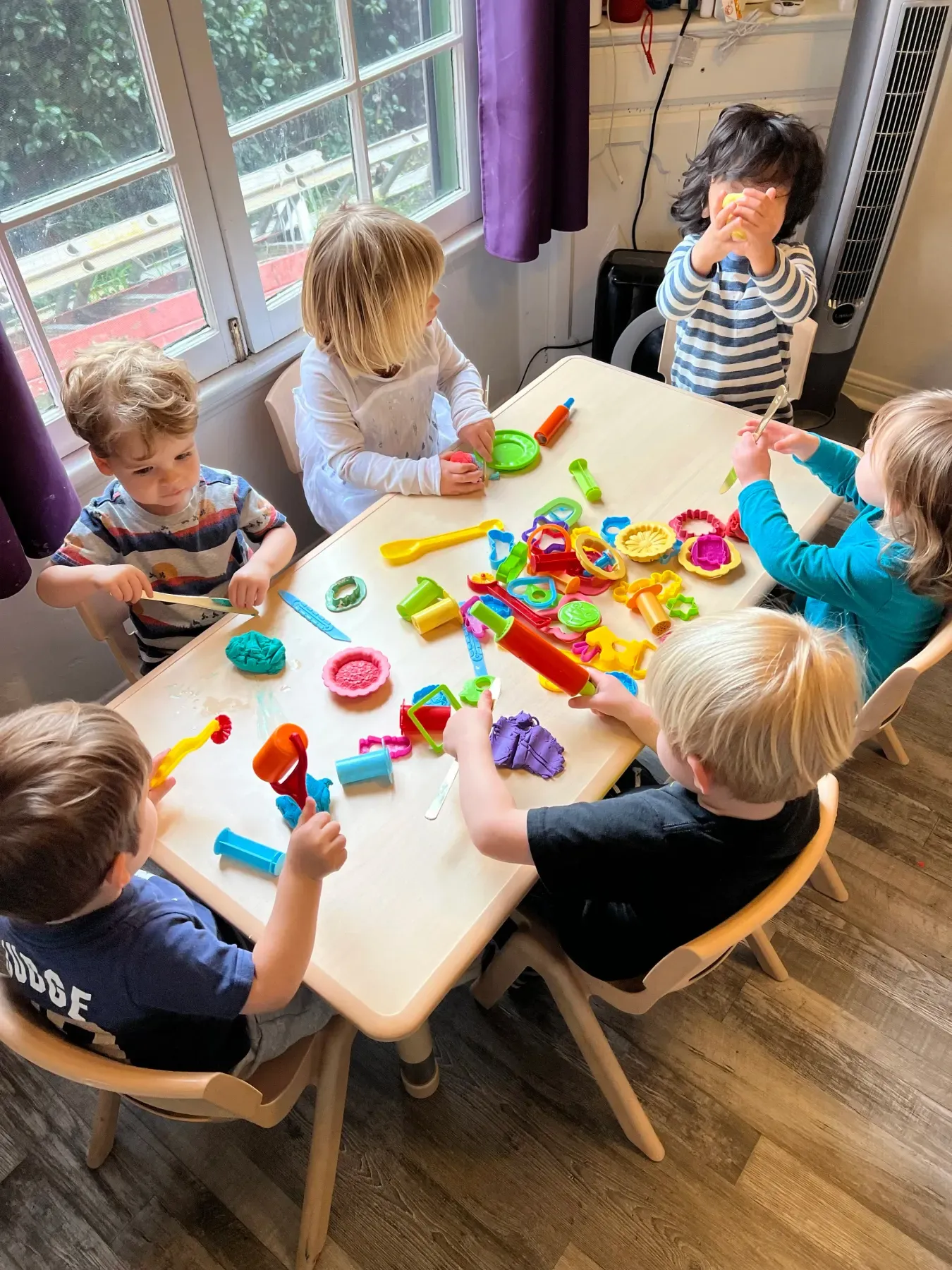 Children playing with playdough around a table